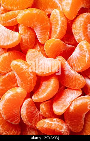 Eine lebendige Nahaufnahme frischer, saftiger Mandarinenscheiben mit ihrem natürlichen, hellen Orange. Perfekt geschälte Segmente zeigen Frische und Zitat Stockfoto