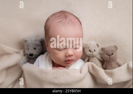 Ein heiteres Neugeborenes schläft ruhig, in eine weiche Decke gehüllt, umgeben von drei Plüschteddybären. Die Szene ruft Wärme, Unschuld und Ruhe hervor Stockfoto