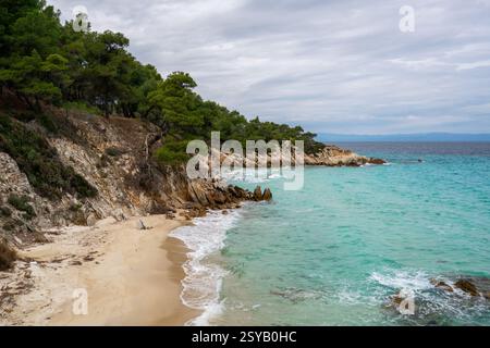 Der Mega Portokali Beach im Süden Griechenlands bietet eine abgeschiedene Sandbucht mit türkisfarbenem Wasser und felsigen Klippen, die mit Kiefern bedeckt sind. Eine ruhige coasta Stockfoto