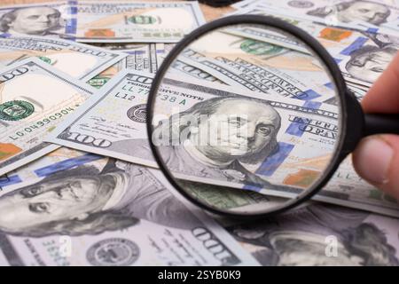 Lupe wird über die Banknote Bündel von US-Dollar gehalten. Stockfoto
