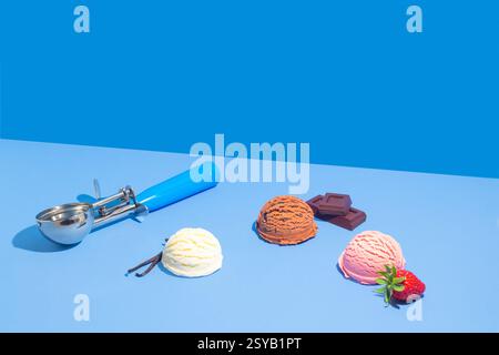 Lebhafte Schoko-, Vanille- und Erdbeereiskrem mit Schokoladentafeln und frischer Erdbeere vor zweifarbigem blauem Hintergrund. Stockfoto