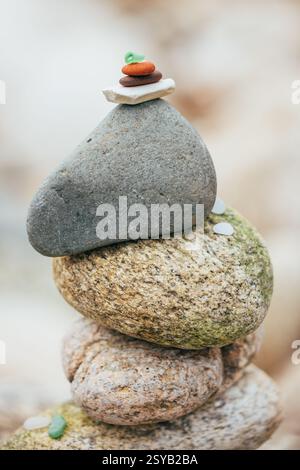 Nahaufnahme balancierter Steine in einer ruhigen Umgebung, mit Schwerpunkt auf verschiedenen Größen und Texturen von übereinander gestapelten Felsen. Der Hintergrund ist Stockfoto