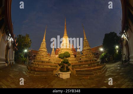 Malerischer Sonnenuntergang mit klassischer thailändischer Architektur mit Pagode im Wat Phra Chetuphon oder Wat Pho. Dies ist einer der größten und ältesten Tempel. Stockfoto