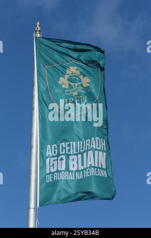 Dublin, Irland - 25. Februar 2025 - Eine grüne Flagge mit IRFU-Logo und irischer Botschaft zum 150-jährigen Bestehen der Organisation fliegt vom Fahnenmast entlang des Flusses Liffey im Stadtzentrum von Dublin Stockfoto