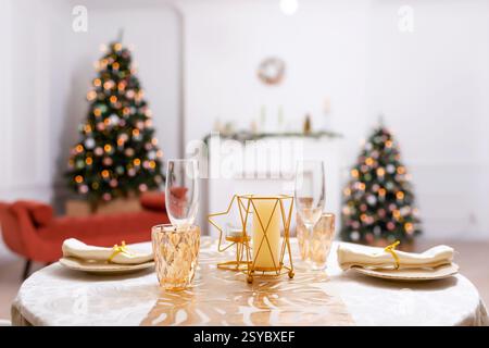 Silvestertisch in einem Fotostudio. Teller mit Gläsern auf einer Weihnachtstischdecke Stockfoto
