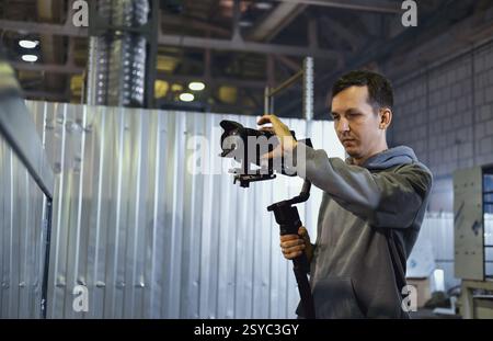 Kameramann stellt Geräte in industriellen Werkstätten auf Stockfoto