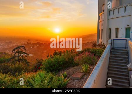 Die architektonische Schönheit des Griffith Observatory, umgeben von einem pulsierenden Sonnenuntergang, zeigt die atemberaubende Landschaft von Los Angeles darunter. Stockfoto