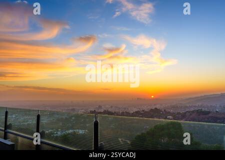 Atemberaubender Sonnenuntergang über Los Angeles, sichtbar von der Aussichtsplattform des Griffith Observatoriums, eingerahmt von Wolken und lebhaften Farben. Stockfoto