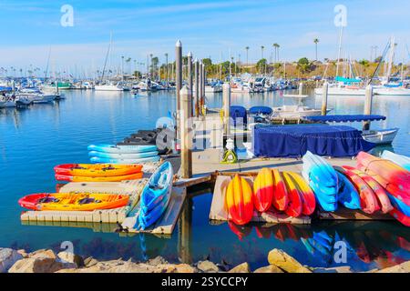 Oceanside, Kalifornien - 27. Dezember 2024: Helle Kajaks am Dock im kalifornischen Yachthafen Oceanside unter klarem blauem Himmel. Stockfoto