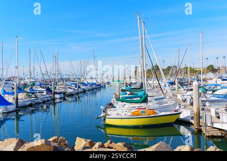Oceanside, Kalifornien - 27. Dezember 2024: Lebhafte Yachthafenszene am Meer mit zahlreichen Segelbooten, die in ruhigem Wasser verankert sind, umgeben von Palmen und Stockfoto