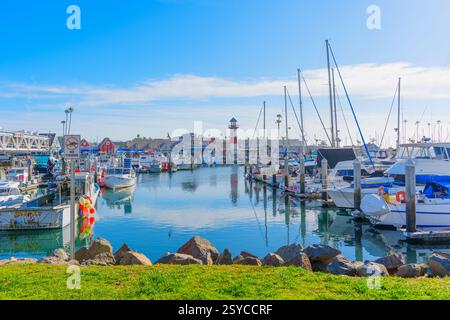 Oceanside, Kalifornien - 27. Dezember 2024: Ruhige Hafenszene mit Booten, die an einem sonnigen Tag im Hafen von Oceanside mit Leuchtturm anlegen. Stockfoto