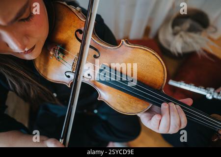 Nahaufnahme eines Musikers, der eine Geige mit Präzision und Fokus spielt Stockfoto