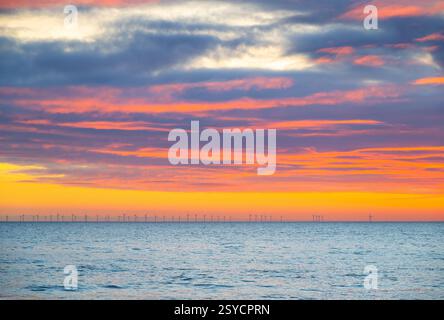 Farbenfroher Sonnenuntergang über dem Ärmelkanal, vom Brighton Beach aus gesehen, mit der Offshore-Windfarm Rampion in der Ferne, City of Brighton und Ho Stockfoto