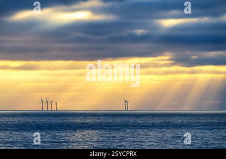 Sonnenuntergang Sonnenstrahlen über dem Ärmelkanal und Rampion Offshore Windpark, vom Brighton Beach aus gesehen, City of Brighton and Hove, East Sussex, Englan Stockfoto