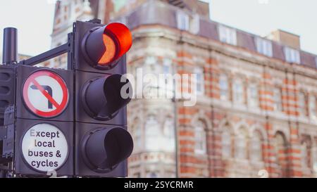 Ampeln mit Reflexionen auf nassen Straßen in einem modernen städtischen Umfeld. Stockfoto