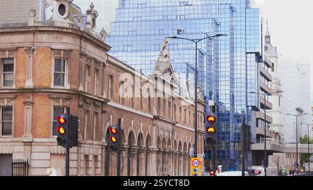 Ampeln mit Reflexionen auf nassen Straßen in einem modernen städtischen Umfeld. Stockfoto