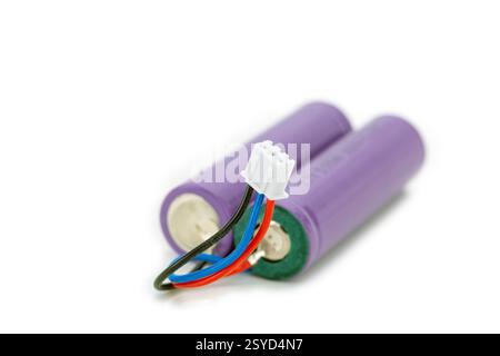 Energiequelle: Nahaufnahme zweier zylindrischer Akkus mit elektrischen Drähten und dreipoligem Steckverbinder. Stockfoto
