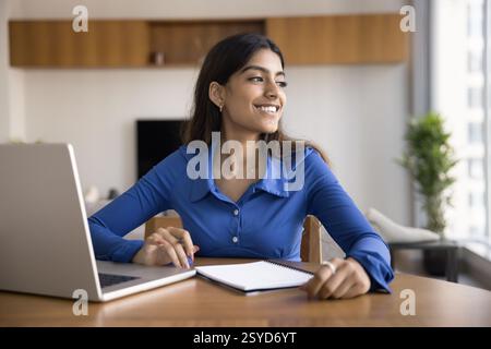 Junge 20er Jahre produktive, motivierte indische Studentin, die am Schreibtisch sitzt Stockfoto