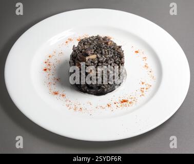 Italienisches Tintenfisch-Risotto, serviert in einem weißen Gericht Stockfoto
