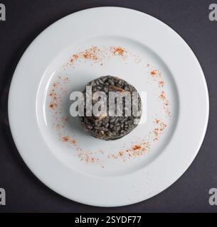 Italienisches Tintenfisch-Risotto, serviert in einem weißen Gericht Stockfoto