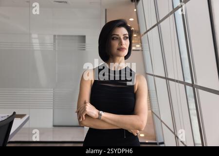Nachdenkliche, reife Geschäftsfrau schaut tief in Gedanken ins Büro Stockfoto