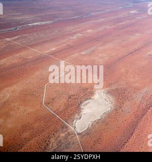 Luftlandschaft mit Pfanne in der Nähe der D1239-Schotterstraße und roten Dünen in der Kalahari-Wüste, aufgenommen von einem Segelflugzeug im hellen Licht des späten Frühlings in der Nähe von Derm, Nam Stockfoto