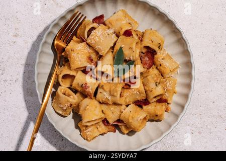 Cremige Butternusskürbis-Pasta mit knusprigem Speck, frischem Salbei und etwas Parmesan Stockfoto
