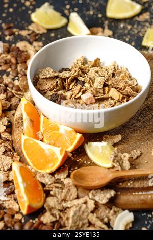 Obstschale Müsli Orangen- und Zitronenscheiben Granola gesundes Frühstücksmenü dunkle Hintergründe unordentliche Tisch Nahaufnahme Stockfoto