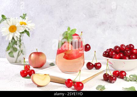 Herbstvitaminglühwein mit Apfelscheiben und Minze. Apfelwein, Saft oder Fruchtgetränk im Glas auf einem sonnigen Tisch, Diät- und Gewichtsreduktion-Konzept. App Stockfoto