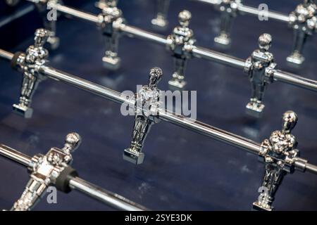 Atemberaubende Metallic-Spieler in einem wettbewerbsfähigen Kicker-Match mit intensiver Action und Strategie in einem lebhaften Spielraum Stockfoto