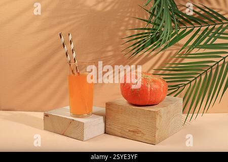 Kürbisgetränk, Saft auf hellem Hintergrund. Modernes Stillleben auf pastellfarbenem Hintergrund mit langen harten Schatten, minimalem Detox-Konzept, traditioneller Dank Stockfoto