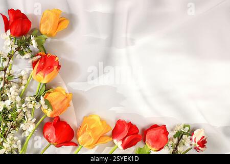 Abstraktes Blumenarrangement mit schönen Frühlingsblüten-Tulpen und Kirschblüten-Zweigen auf elegantem sonnigem Hintergrund. Stillleben mit Platz für t Stockfoto