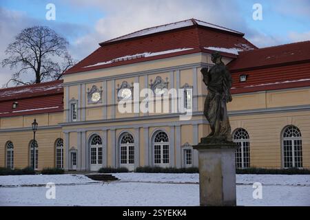 Schnee bedeckt den Garten und eine historische Statue vor dem neuen Flügel des Schlosses Charlottenburg, Berlin, an einem Wintertag Stockfoto