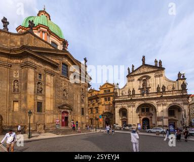 Eine barocke Kirche mit einer symmetrischen Fassade mit Statuen, Bogenöffnungen und einer markanten grünen Kuppel befindet sich auf einem Stadtplatz Stockfoto