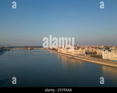 17.02.2024, Budapest. Aus der Vogelperspektive auf das ungarische Parlamentsgebäude und die Donau mit einer Brücke im Hintergrund, an einem sonnigen Tag mit c Stockfoto