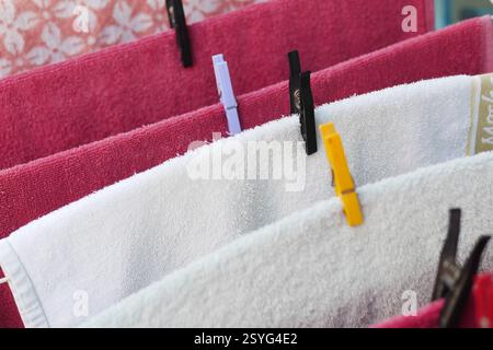 Handtücher trocknen auf einer Wäscheleine unter Sonnenlicht im Hinterhof Stockfoto