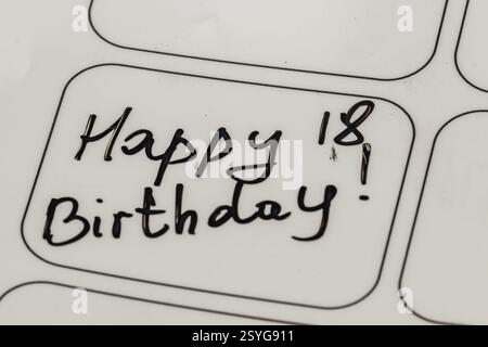 Eine fröhliche Botschaft, die den 18. Geburtstag feiert, ist handgeschrieben in kräftiger schwarzer Tinte. Der Text vermittelt Begeisterung und Freude für diese besondere Meilensteinmutter Stockfoto