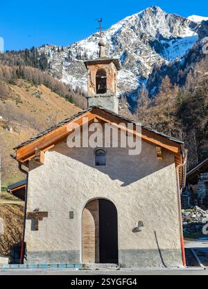 Kleine Kapelle in einem Dorf der französischen alpen am Fuße eines schneebedeckten Berges Stockfoto