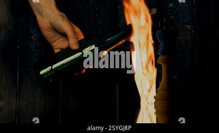 Schachkönig in den Farben der ukrainischen Flagge vor dem Hintergrund einer Frauenhand mit einem brennenden Molotow-Cocktail, mutige Ukraine, Ukrainisch Stockfoto