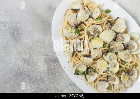Spaghetti mit Vongole Venusmuscheln, in Sahnesauce, Carbonara, auf einem weißen Teller, hausgemacht, Blick von oben, keine Leute Stockfoto
