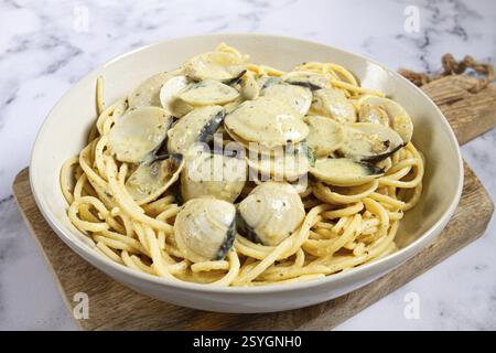Spaghetti mit Vongole Venusmuscheln, in Sahnesauce, Carbonara, auf einem Marmortisch, hausgemacht, Blick von oben, keine Leute Stockfoto