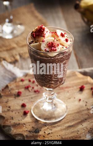 Gesunder Schokoladen-Bananenchia-Pudding in einem Glasbecher auf einem Tisch Stockfoto