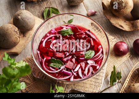 Zubereitung von fermentiertem Rübenkwass in einer Glasschale mit frischer Roter Bete, Zwiebeln, Knoblauch und Lorbeerblatt Stockfoto