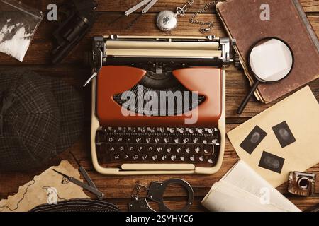 Schreibmaschine, Fingerabdrücke, Lupe und Papiere auf dem Schreibtisch des Detektivs Stockfoto