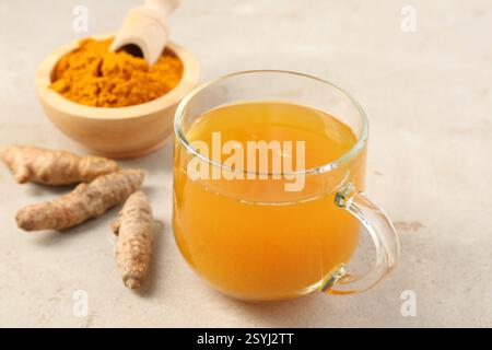 Aromatischer Kurkuma-Tee, Rhizome und Pulver auf weißem texturiertem Tisch, Nahaufnahme Stockfoto