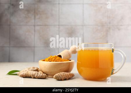 Aromatischer Kurkuma-Tee, Rhizome und Pulver auf weißem, strukturiertem Tisch Stockfoto