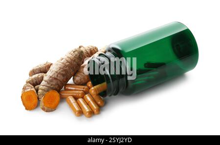 Kurkuma Kapseln, Wurzeln und umgedrehte medizinische Flasche isoliert auf weiß Stockfoto