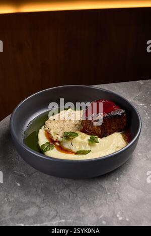 Rindersteak mit cremigem Kartoffelpüree, Gourmet-Sauce, garniert mit Kräutern, elegant präsentiertes Gourmet-Gericht, kulinarisches Delikatessen-Konzept Stockfoto