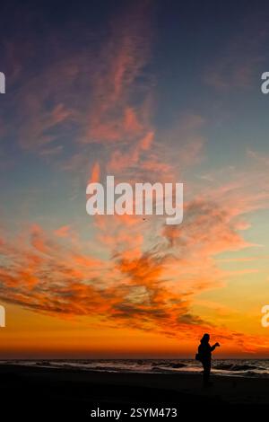 Isle Of Palms, Usa. März 2025. Ein Fotograf wird vom Sonnenaufgang über dem Atlantischen Ozean am Front Beach am 1. März 2025 in Isle of Palms, South Carolina, gesehen. Eine allmähliche Erwärmung bis in die 70er Jahre wird sich nach einem harten Winter im Tiefland fortsetzen. Quelle: Richard Ellis/Richard Ellis/Alamy Live News Stockfoto