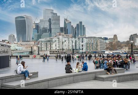 London, Großbritannien - 21. März 2024 : Touristen besuchen das Ufer der Themse in London mit der Skyline im Hintergrund. Stockfoto